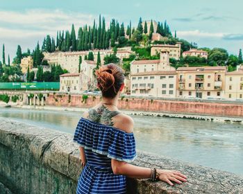 Rear view of woman looking at city against sky