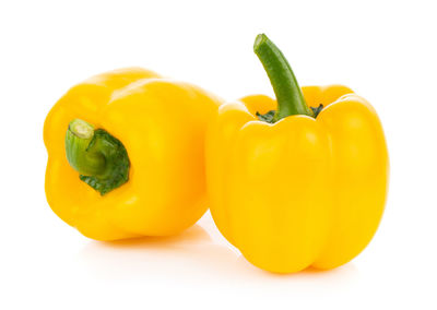 Close-up of yellow bell peppers against white background
