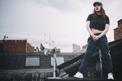 Portrait of young woman standing on rooftop