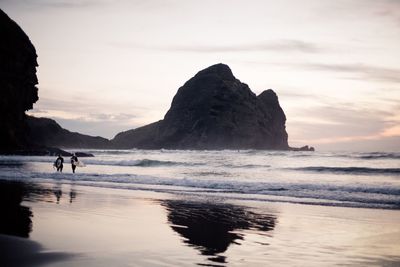 Silhouette of surfers on beach