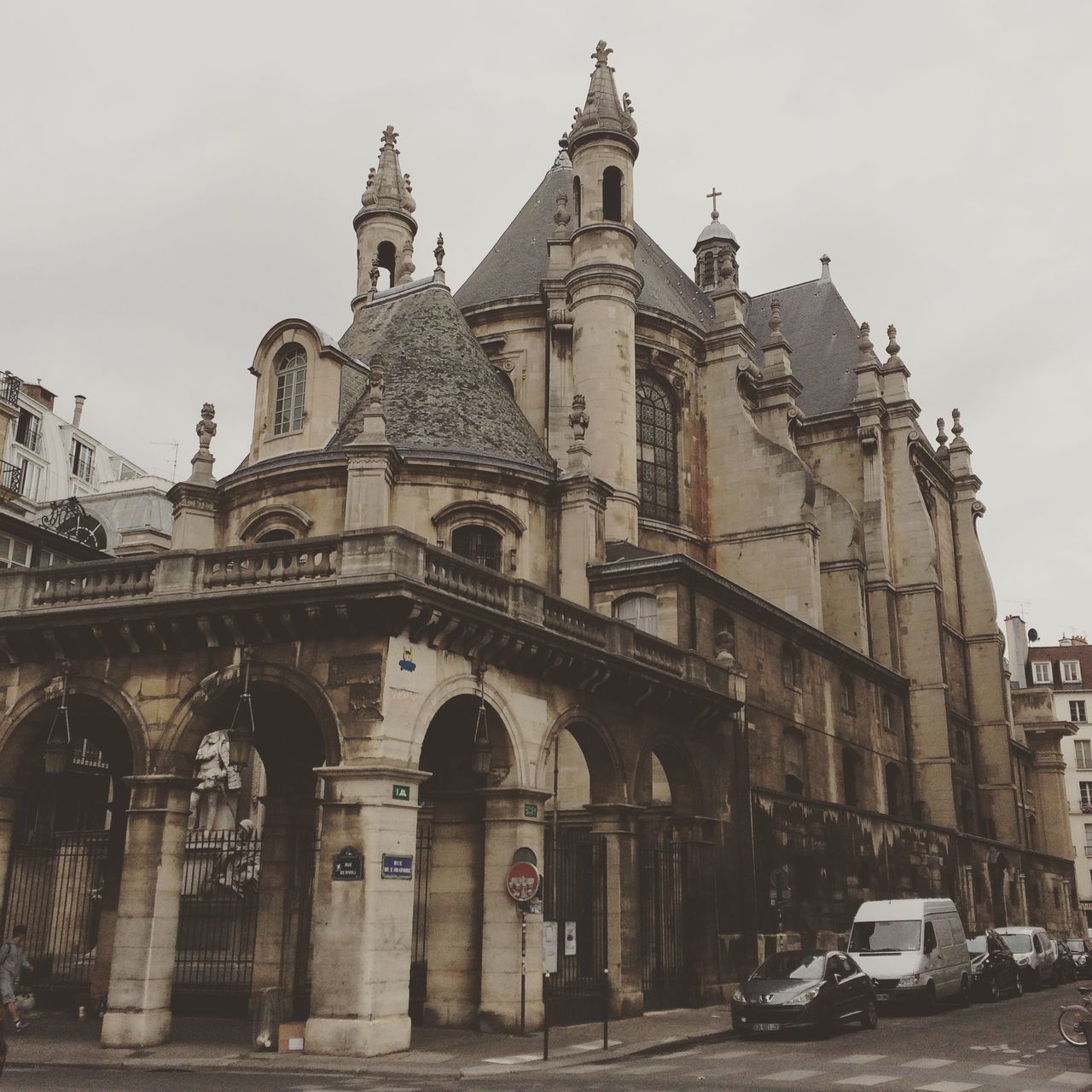 architecture, building exterior, built structure, religion, church, place of worship, transportation, spirituality, sky, car, low angle view, mode of transport, land vehicle, street, city, cathedral, facade, incidental people