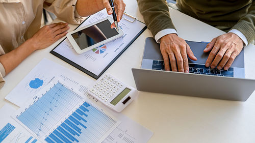 High angle view of people and laptop on table