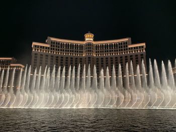 View of fountain in city against sky at night