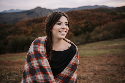 Portrait of smiling young woman standing on mountain