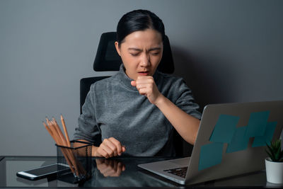 Man using mobile phone while sitting on table