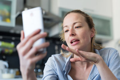 Businesswoman talking on phone working at home