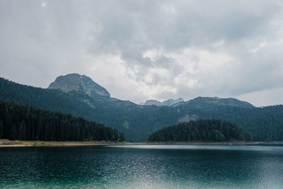 Scenic view of lake by mountains against sky