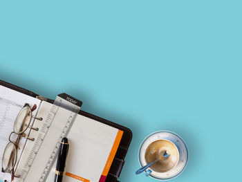 High angle view of books on table against blue background