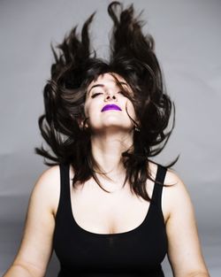 Studio shot of young woman with tousled hair