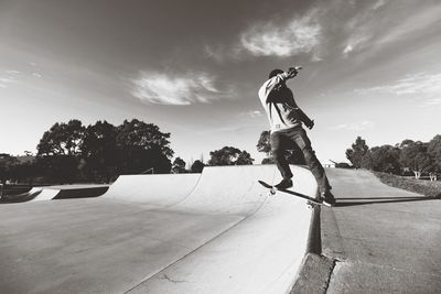 Man skateboarding on skateboard against sky