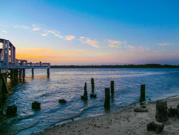 Pier on sea against cloudy sky