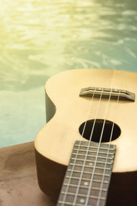 Close-up of guitar on table at poolside