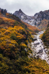 Scenic view of waterfall against sky during autumn