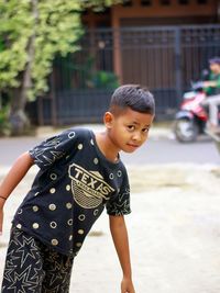 Side view of boy looking away while standing outdoors