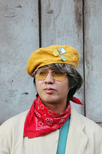 Portrait of young man standing against wall