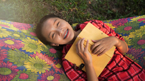 Portrait of smiling teenage girl on hammock