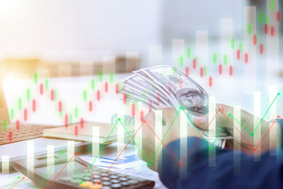 Digital composite image of man and umbrellas on table