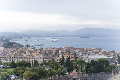 High angle view of townscape by sea against sky