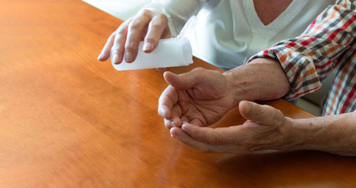 Midsection of man holding while sitting on table