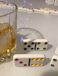 Close-up of dominoes by drink on table