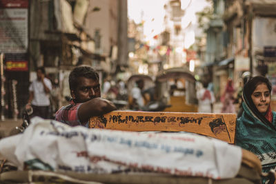 Portrait of man leaning on pedicab at street