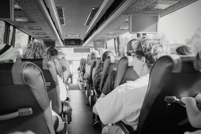 Rear view of people sitting on seats in bus