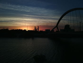 Reflection of built structures in water at sunset