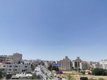 Buildings in city against clear blue sky