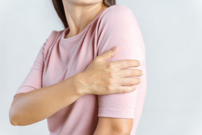 Midsection of woman standing against white background