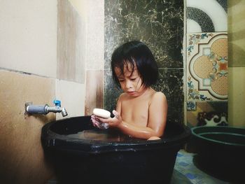 Young woman using mobile phone in bathroom at home