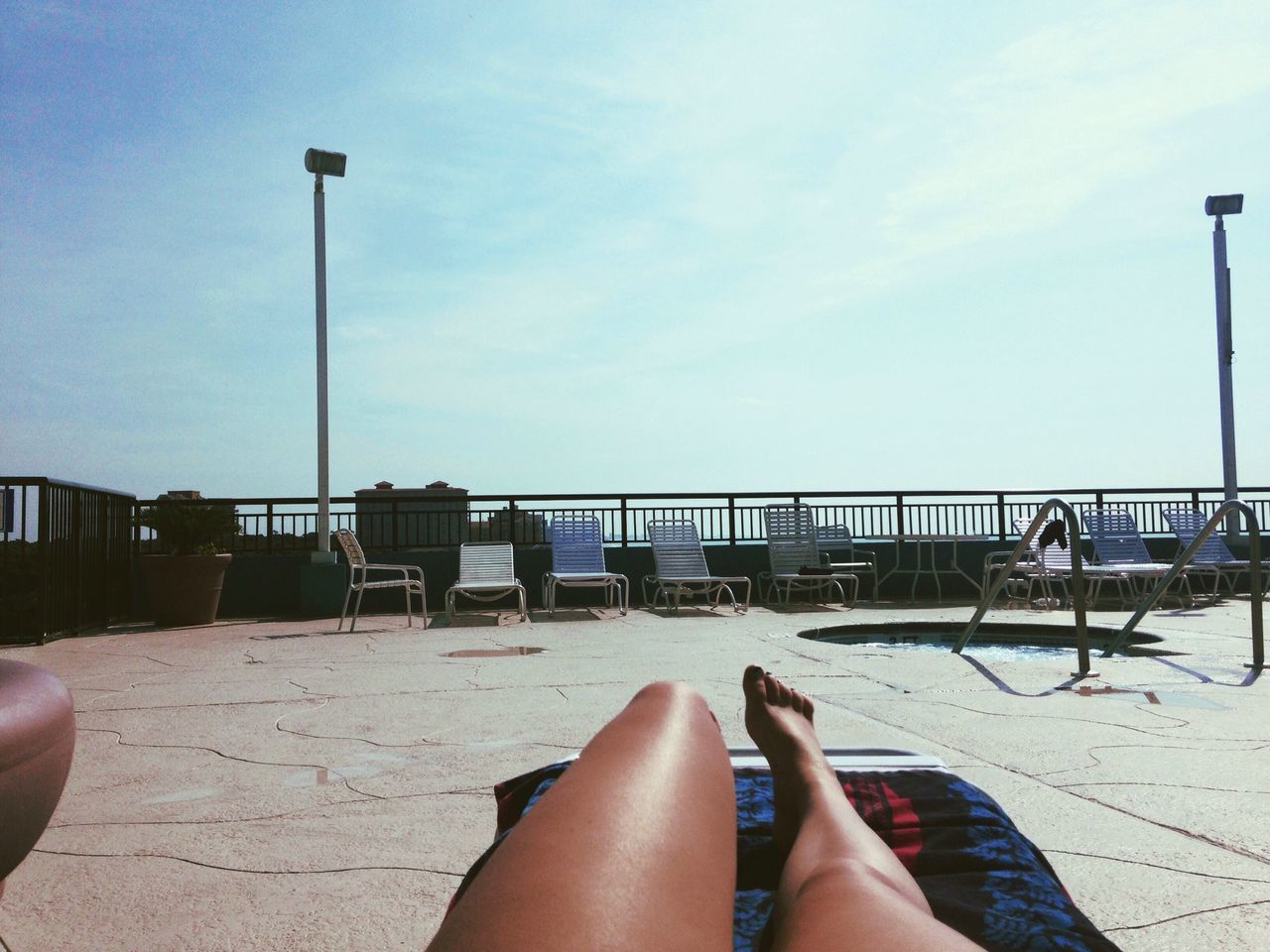 personal perspective, person, low section, sea, sky, part of, water, lifestyles, barefoot, leisure activity, cropped, railing, relaxation, human foot, beach, horizon over water