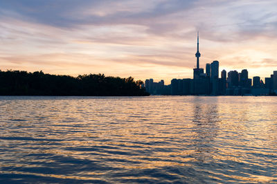 View of city at waterfront during sunset