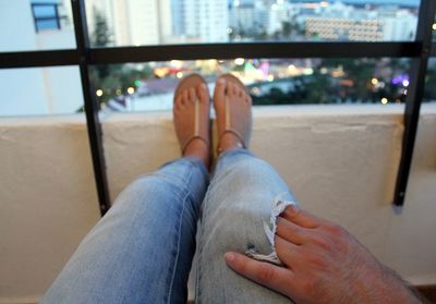 Cropped hand of man putting hand in friends torn jeans