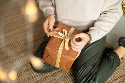Women's hands unpack christmas gifts in eco-packaging