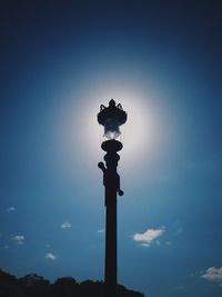 Low angle view of illuminated lamp in city against sky