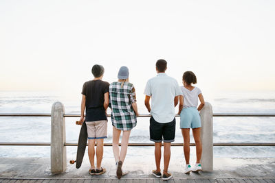 Rear view of couple walking at beach