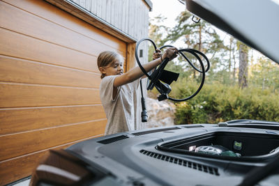 Boy putting charger in car storage compartment