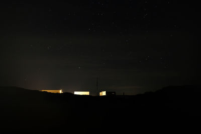 Silhouette buildings against sky at night