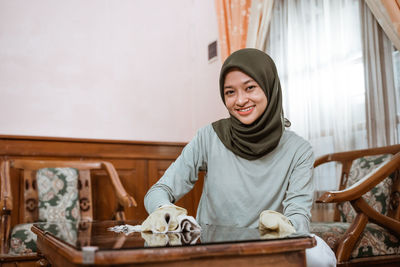 Portrait of young woman sitting at home