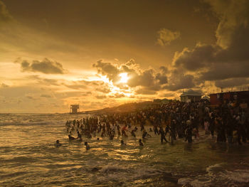 Crowd on beach during sunset