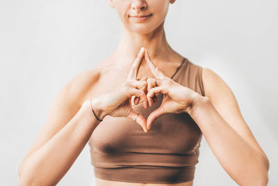 Portrait of woman sitting against white background