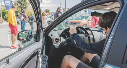 People sitting in car seen through window