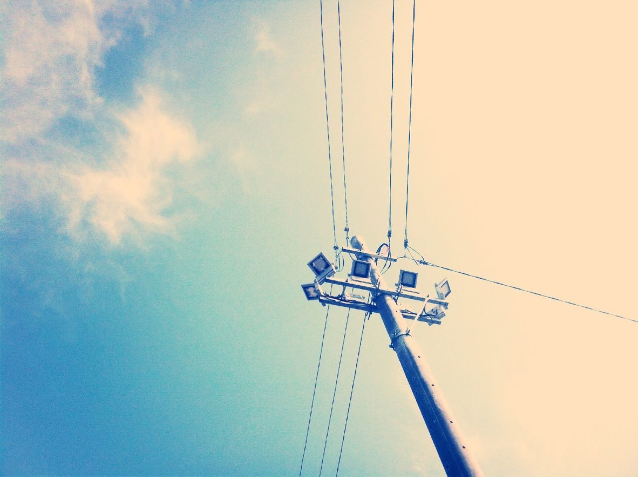 low angle view, sky, technology, fuel and power generation, clear sky, electricity, no people, outdoors, day, blue, connection, copy space, power supply, cable, transportation, metal, communication, nature, power line, pole