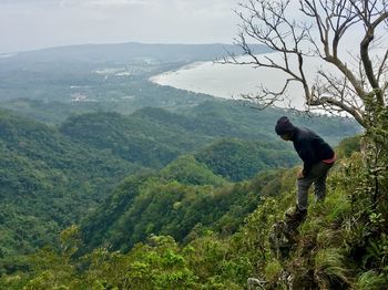 Man standing on mountain against sky