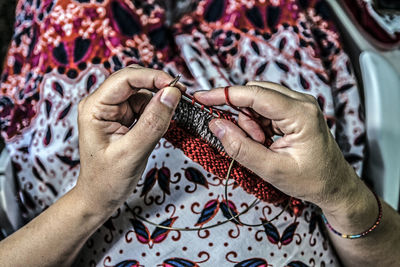 Midsection of woman knitting wool