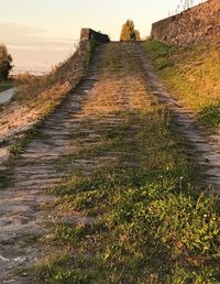 Road amidst field against sky