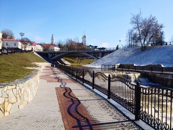 Bridge over river in city against clear sky