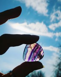 Low angle view of hand holding multi colored sky