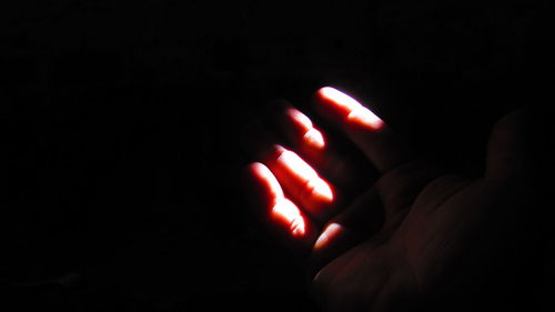 Close-up of human hand against black background