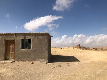 House on desert against sky